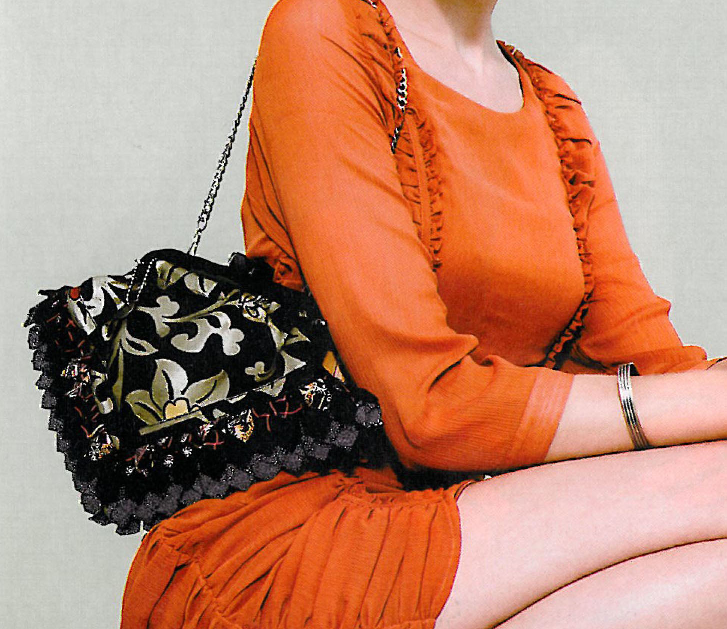 model with orange dress and handbag